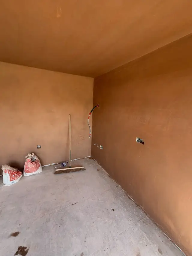 Small room with vibrant orange plaster walls